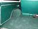 1978 Ford Bronco - Interior view of a vehicle's cargo area, green carpeting and ribbed side paneling.