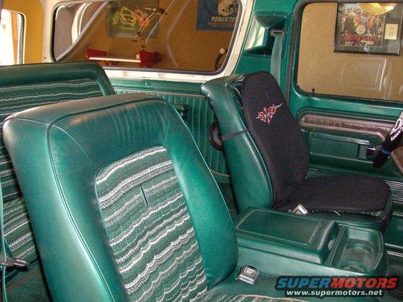 Green interior of a 1978 Ford Bronco with striped seats and a center console