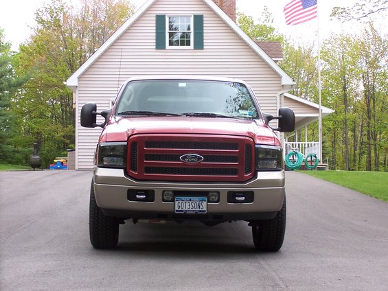 2005 Ford Super Duty truck front view, red and tan, parked in driveway
