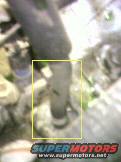 Close-up of a rubber vacuum hose connected to a metal fitting, with a yellow box highlighting the connection