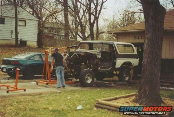 White and brown 1978 Ford Bronco with engine removed, viewed from the front-side