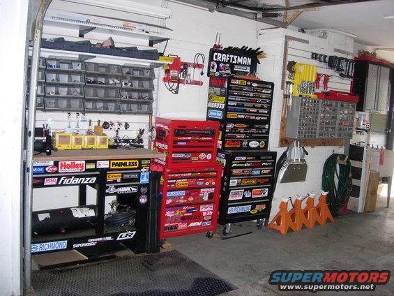 Garage workshop with tool chests, workbench, and parts storage shelves. Craftsman logo visible