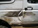 1996 Ford Bronco - This 1996 Ford Bronco shows significant damage to the side door and fender, covered in mud.