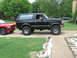 1994 Ford Bronco - A black 1994 Ford Bronco is parked next to a red Dodge Dakota.