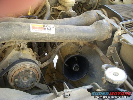 Engine bay showing air intake tubes with K&N filter sticker, AC compressor, and radiator cap