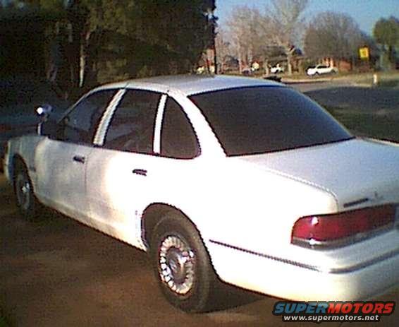 1995 Ford Crown Victoria sedan, side view. White paint, tinted windows
