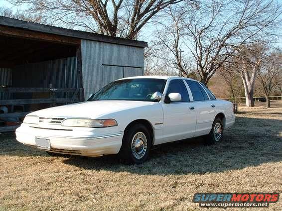 White 1995 Ford Crown Victoria parked in front of a shed