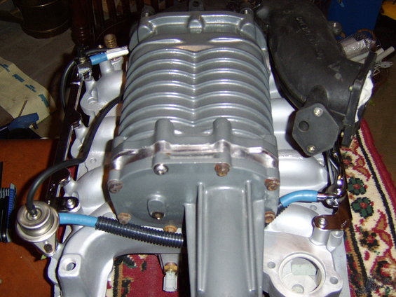 sta71742.jpg Test fit on the manifold. 

Still a little tight, but it clears. The fuel rail inlet, outlet  and the one crossover barb which is on a tube rather than attached to rail were all slightly bent for clearance.


Note the blower case color before I painted it.Can also see a test fit of one of the stainless button socket head screws (M8x1.25)