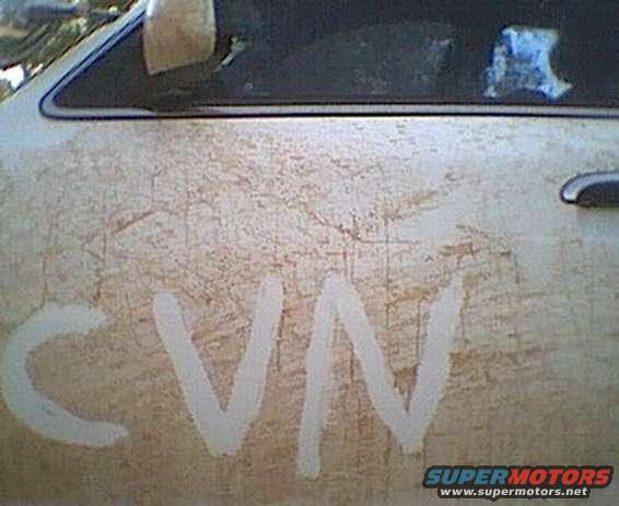 Dirty car door with 'CVN' written in white, side view