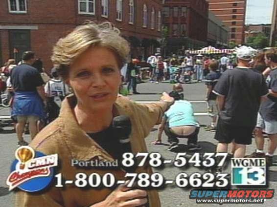 Woman with microphone in front of a crowd, with phone numbers and logos overlaid