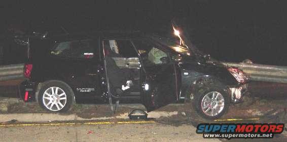 Black SUV with driver's side doors open, damaged front end, parked on roadside