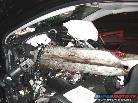 Damaged car interior with deployed airbags and exposed wiring