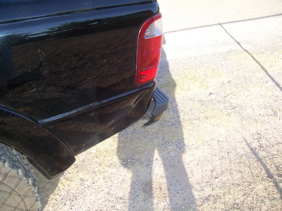 Rear corner of a black 2003 Ford Ranger pickup truck, showing the taillight and bumper