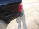 2003 Ford Ranger - The rear section of a black pickup truck is visible, including the taillight and a damaged bumper.