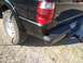 2003 Ford Ranger - A black 2003 Ford Ranger shows damage to its rear quarter panel and bumper, with a visible tire and taillight.
