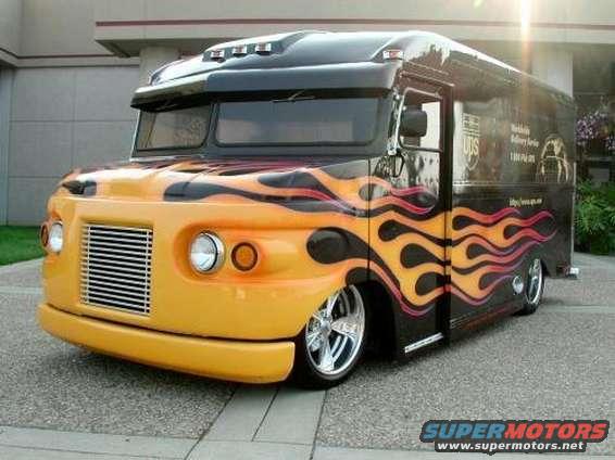 Custom delivery truck with orange and yellow flames on black body, chrome grille, and custom wheels