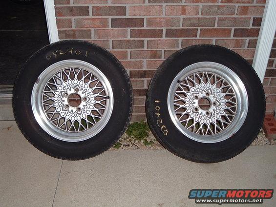 Two aftermarket mesh wheels with tires, one has '632401' written on it, the other has '1972401'