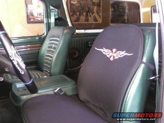 Interior view of green vehicle with tribal cross seat cover and Beatles poster
