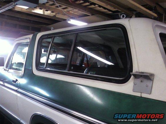 1978 Ford Bronco side view, green and white paint, in a garage