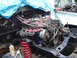 1979 Ford Bronco - The engine bay of a vehicle is partially covered by a blue tarp, with red springs and tools visible.