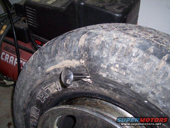 Tire with a nail and a metal object pushed through it