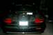 1996 Chevrolet Impala - The trunk of a 1996 Chevrolet Impala is open, revealing a spare tire and the car's interior. The rear taillights are red.