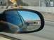 1996 Chevrolet Impala - View from a car's side mirror shows traffic on a highway with an overpass in the distance.