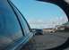 1996 Chevrolet Impala - A dark SUV is visible in the side mirror of a car on a sunny day on the highway.