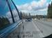 1996 Chevrolet Impala - Traffic on a highway under a cloudy sky, as seen from the passenger side window.