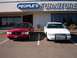1996 Chevrolet Impala - Two sedans are parked in front of a furniture store.