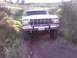 1978 Ford Bronco - This 1978 Ford Bronco is shown driving off-road on a dirt path with vegetation on either side.
