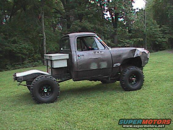Modified pickup truck with flatbed, toolbox, and large tires