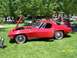 1972 Ford Ranchero - A red 1963 Corvette Sting Ray coupe is displayed with its hood open at an outdoor car show.