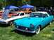 1972 Ford Ranchero - A turquoise 1955-1957 Ford Thunderbird is displayed at a car show with other vehicles in the background.