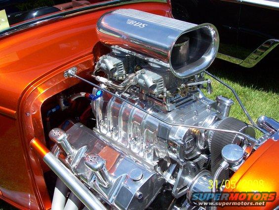 Custom V8 engine with chrome air intake and orange bodywork visible