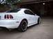 1997 Ford Mustang - Rear 3/4 view of a white 1997 Ford Mustang coupe with black rims parked in a driveway.