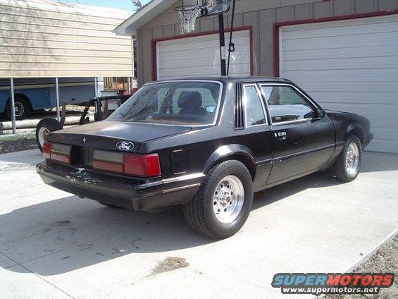 Black 1986 Ford Mustang coupe parked in a driveway