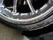 2002 BMW 3 Series - Close-up of a damaged chrome wheel and tire, showing scuff marks on the rim and text on the tire sidewall.