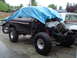1979 Ford Bronco - This black 1979 Ford Bronco is partially covered by a blue tarp, revealing its lifted suspension and large off-road tires.