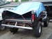 1979 Ford Bronco - Rear view of a 1979 Ford Bronco pickup truck with its bed covered by a blue tarp.