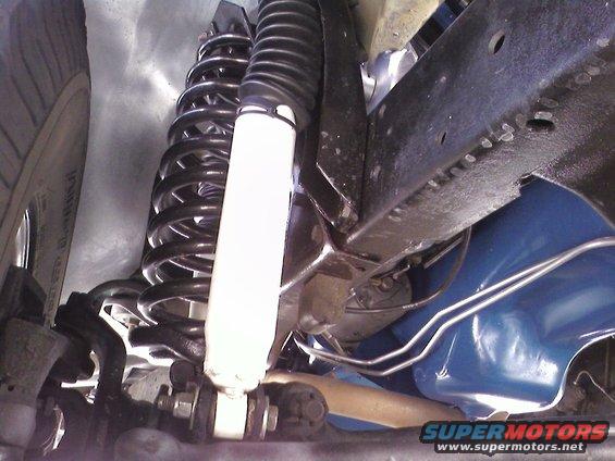 close-up of vehicle's front suspension with coil springs and shock absorber