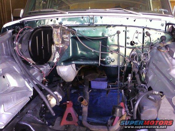 engine bay of a vehicle with parts removed, showing the firewall and some wiring