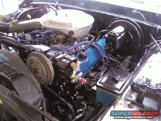 Engine bay of a 1978 Ford Bronco with a blue valve cover and chrome air cleaner