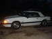 1990 Ford Mustang - A white convertible with a 5.0 badge is parked on a concrete surface at night, with another vehicle visible in the background.