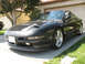 1995 Ford Probe - This black sports coupe is parked in a driveway with a garage in the background.
