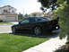 1995 Ford Probe - A black 1995 Ford Probe is parked in a residential driveway, seen from the rear quarter angle.