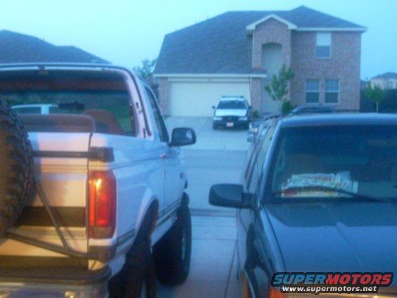 1992 Ford Bronco parked next to a dark SUV in a driveway