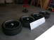 1996 Ford Probe - Four aftermarket wheels and tires are laid out on a garage floor next to a cardboard box.