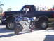 1991 Ford Bronco - A silver sport motorcycle is parked in front of a black 1991 Ford Bronco.