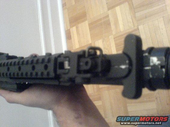 Close-up of firearm receiver and stock held in hand
